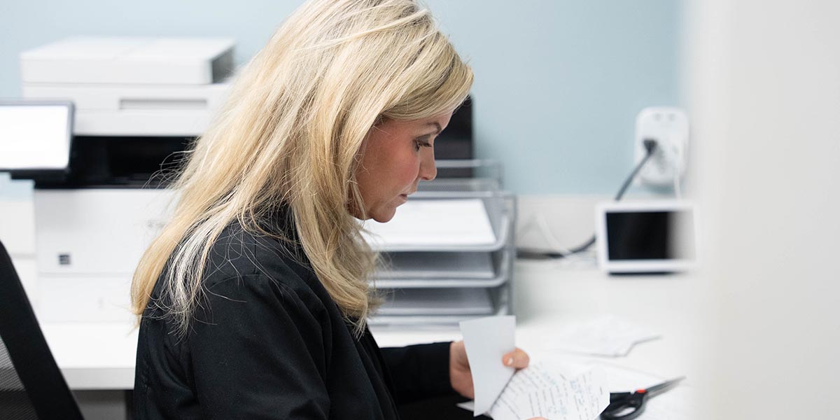 A female staff member does the paperwork inside the Whiteville Family and Cosmetic Dentistry office.